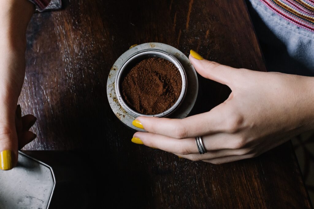 Woman Holding a Bowl of Ground Coffee Powder 